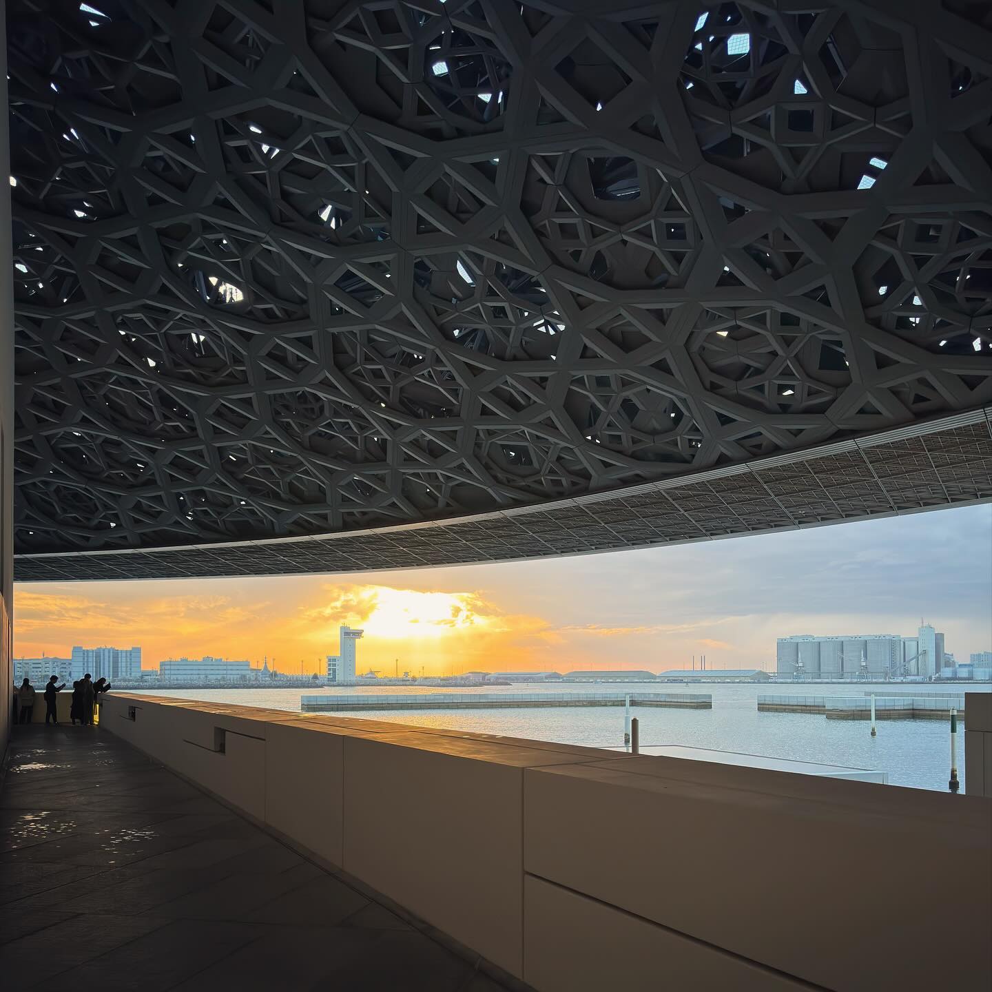 The low sun illuminates the water beneath the patterned dome.