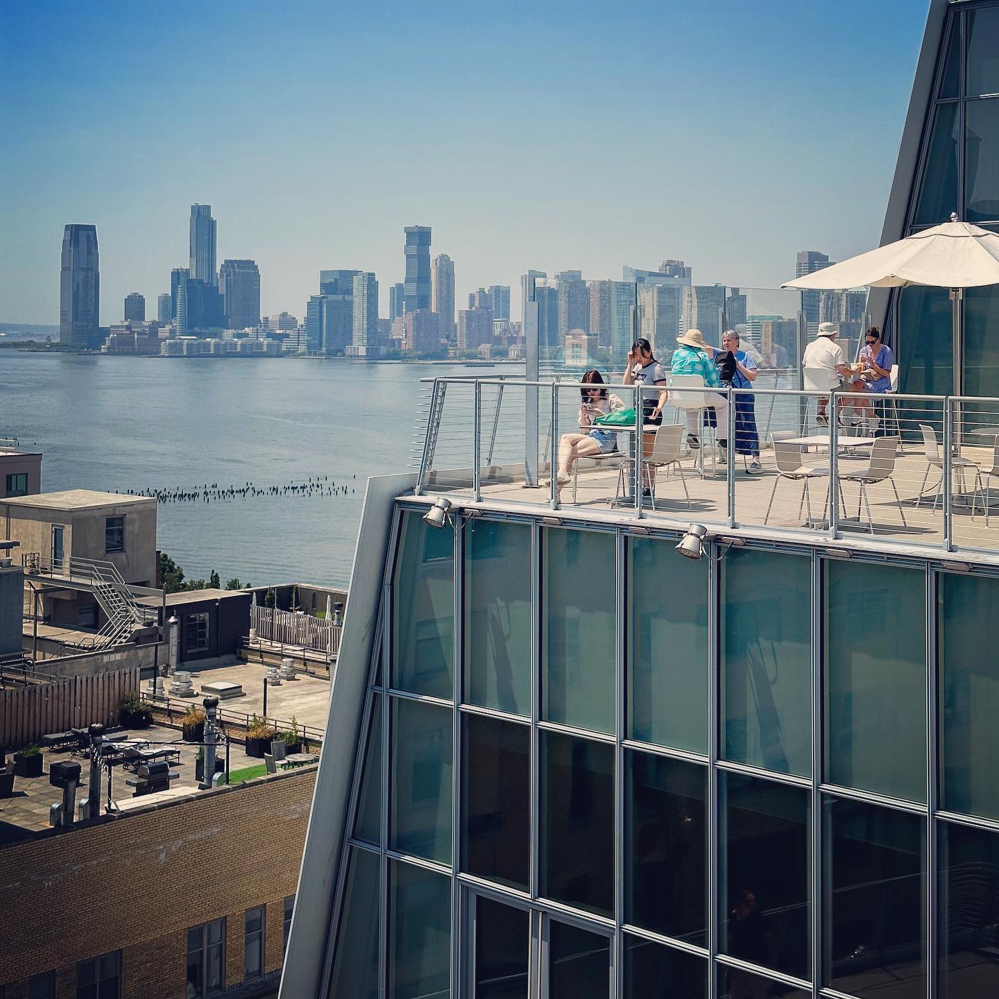 Visitors on an outdoor museum terrace overlooking the Hudson River.