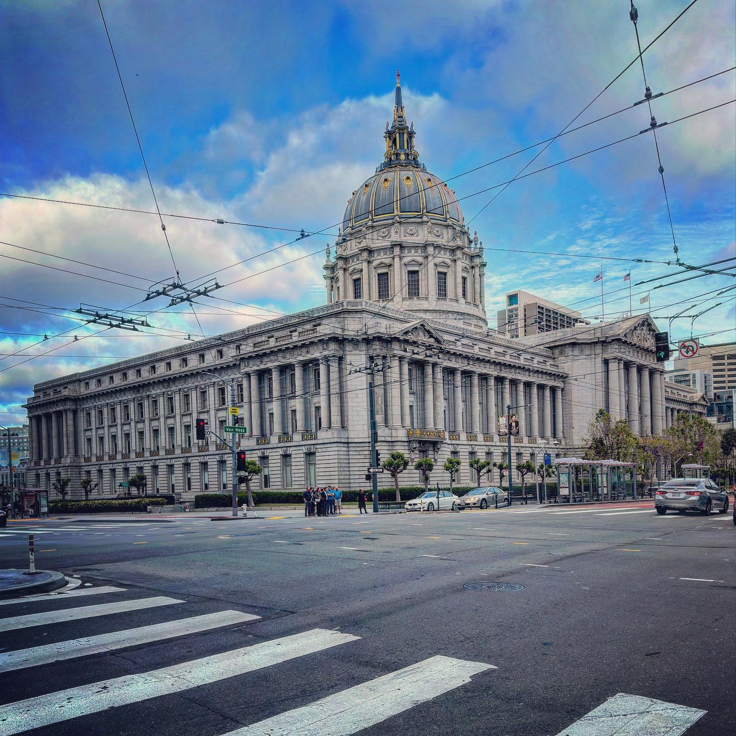 San Francisco City Hall’s dome and columned frontage beyond a street crossing.