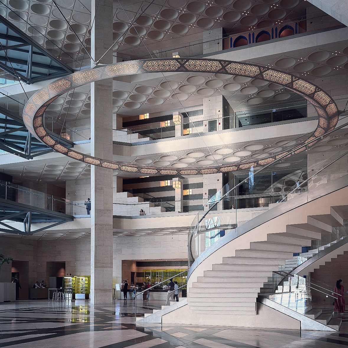 A circular suspended feature and paired stairways within the museum’s layered atrium.