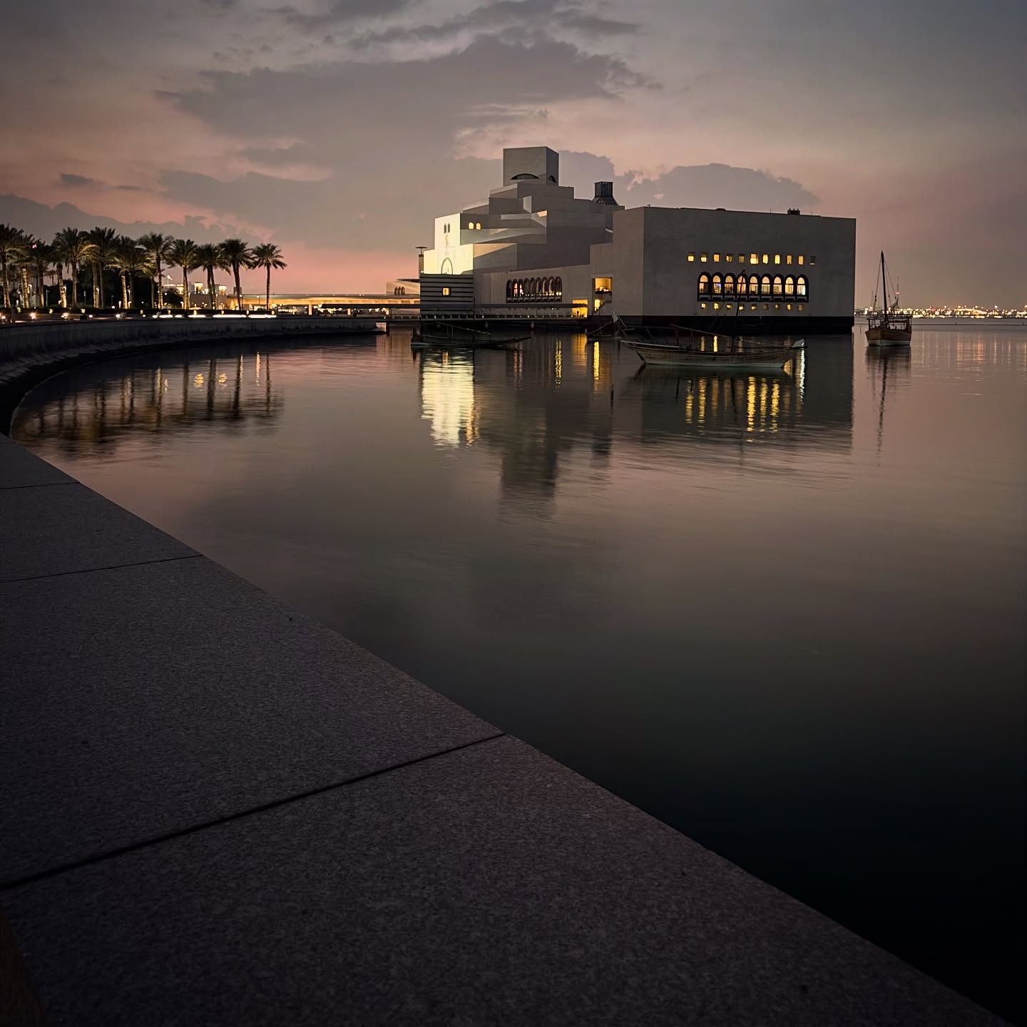 The museum reflected in still water beneath the evening sky.