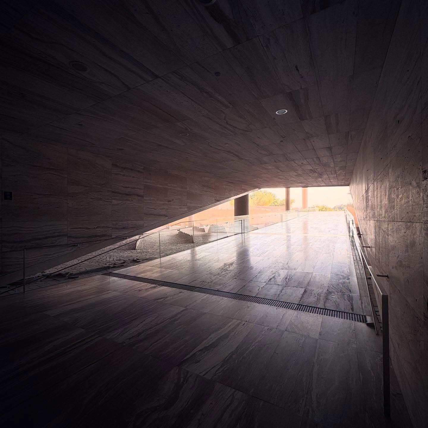 A dark passage opening towards daylight inside Qatar National Library.