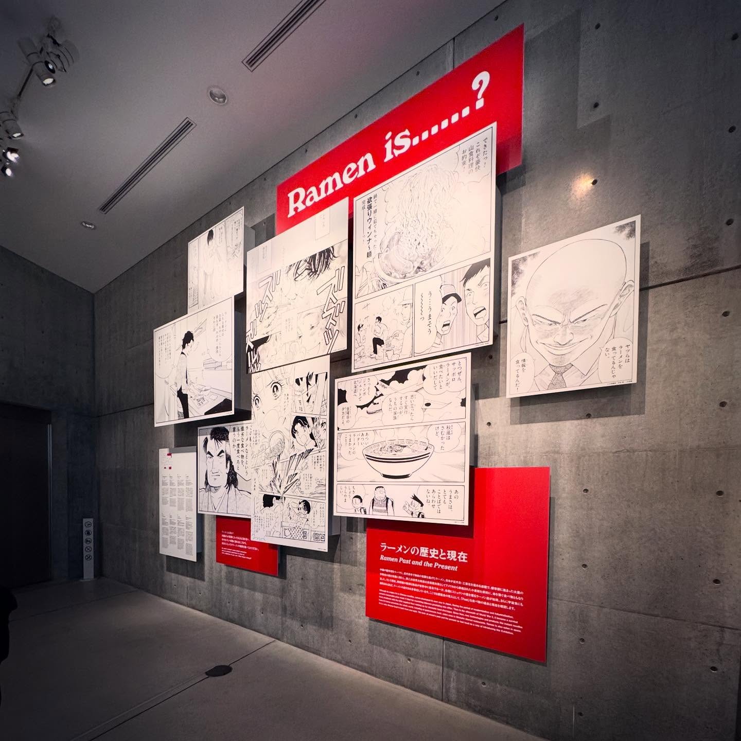 Exhibition panels and drawings arranged against exposed concrete.
