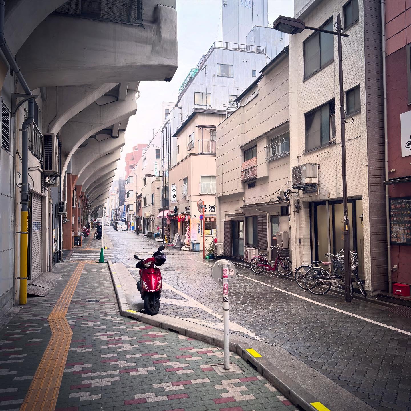 A small street and pavement following the structure of an elevated railway.