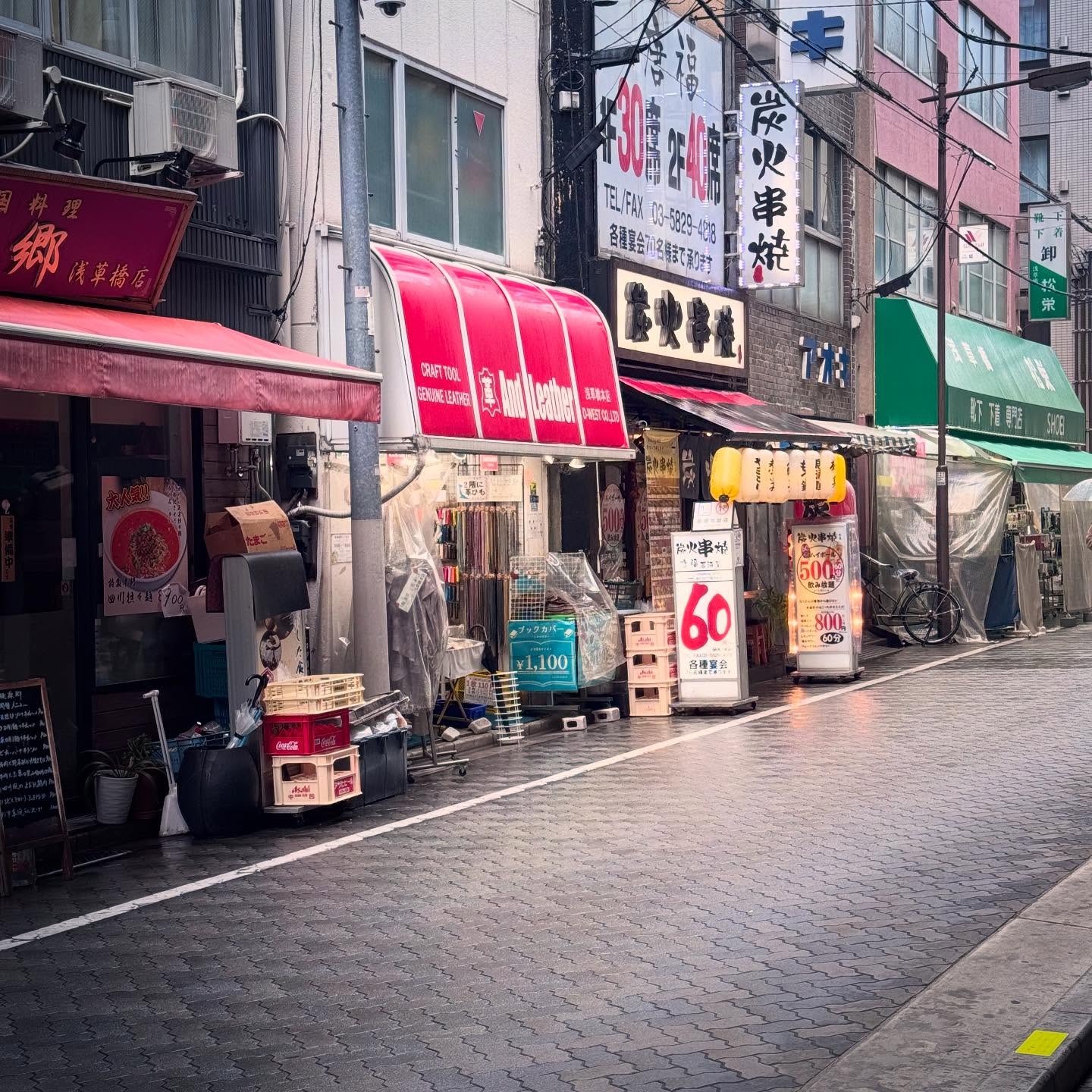 Colourful signs, small restaurants and wet paving on a Tokyo lane.