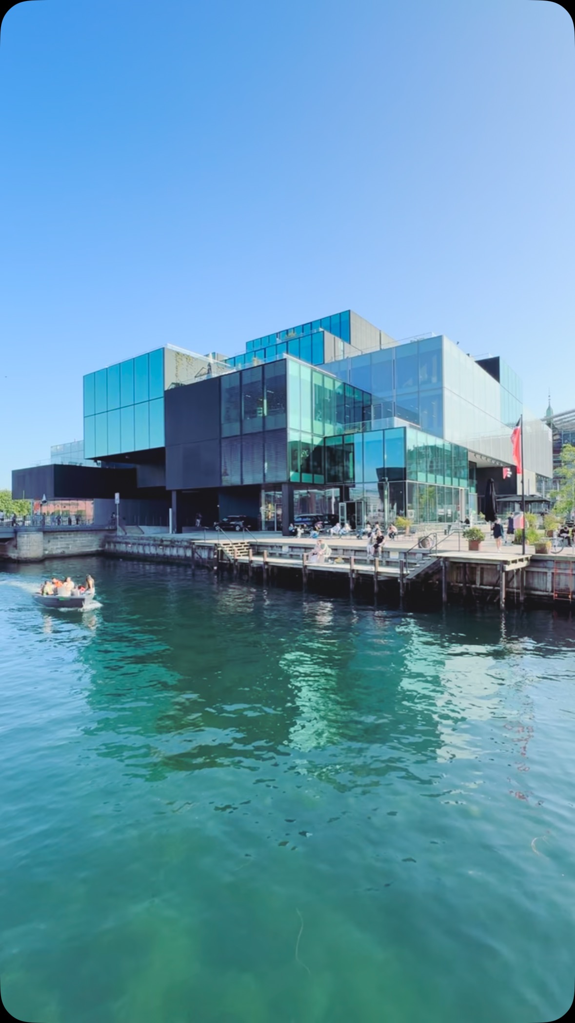 Reel cover showing BLOX’s stacked glass volumes beside the water.