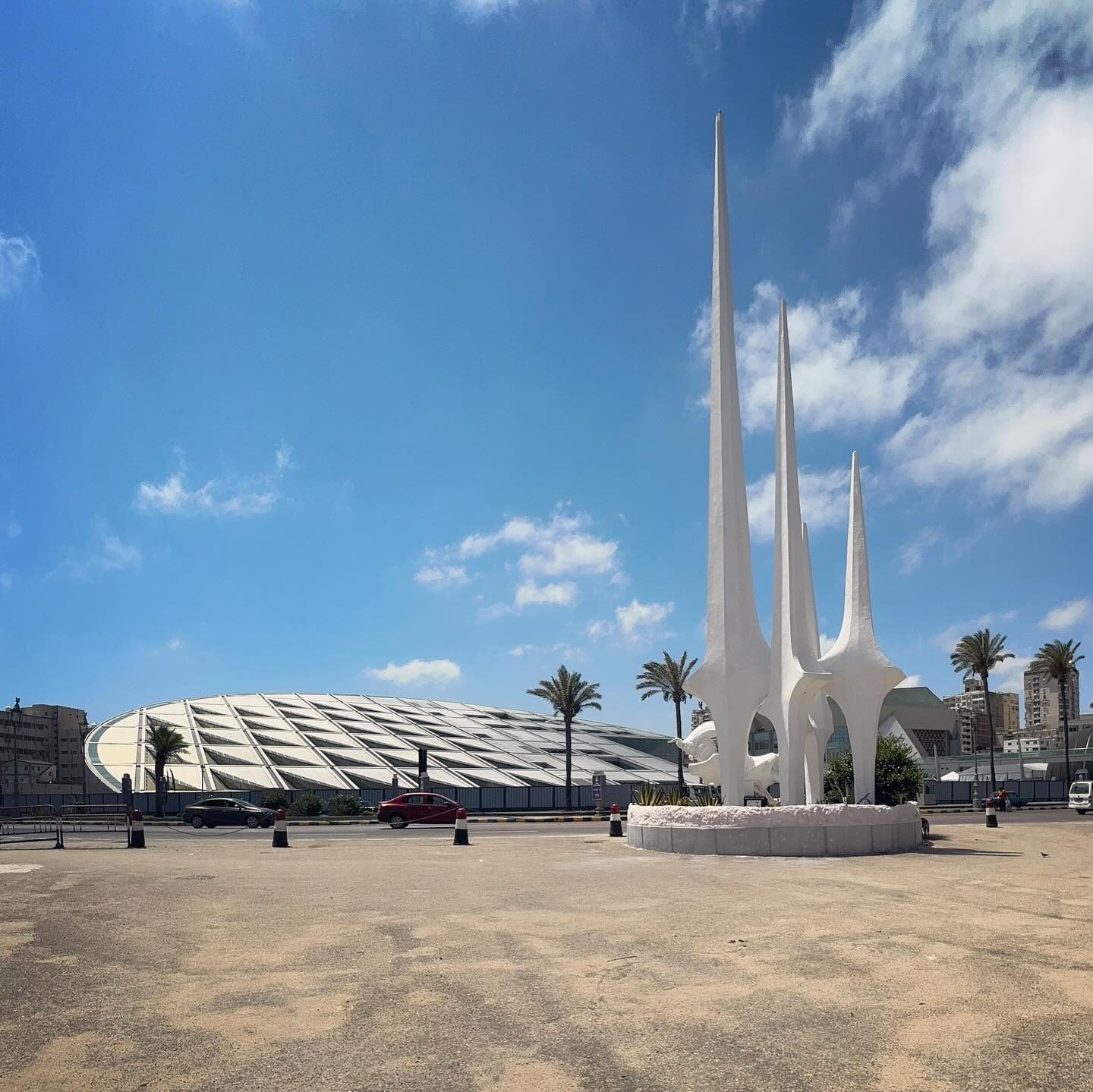 A dome and slender minarets beside an open paved space in Chatby.