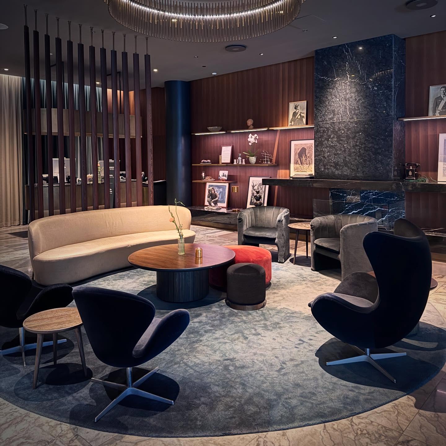 Sculptural lounge chairs and a pale curved sofa arranged around low tables.