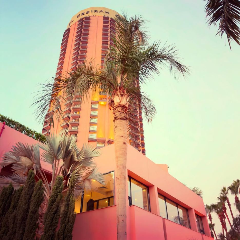 The rounded Sofitel Cairo Nile El Gezirah tower framed by palms.