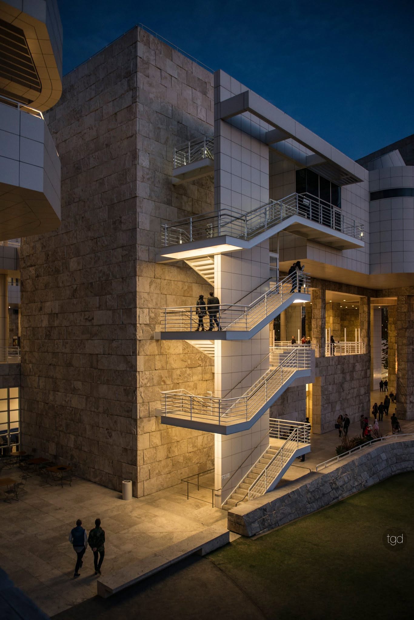 Illuminated stairs and stone façades at the Getty Center against a deep blue evening sky.