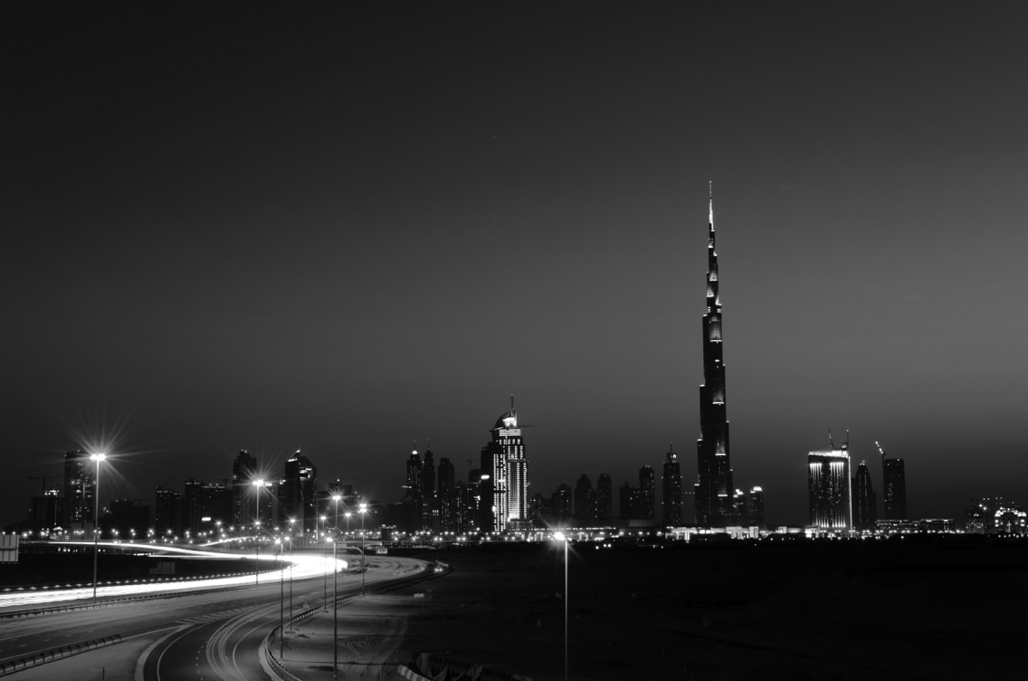 Burj Khalifa and the Dubai skyline with light trails in the foreground.