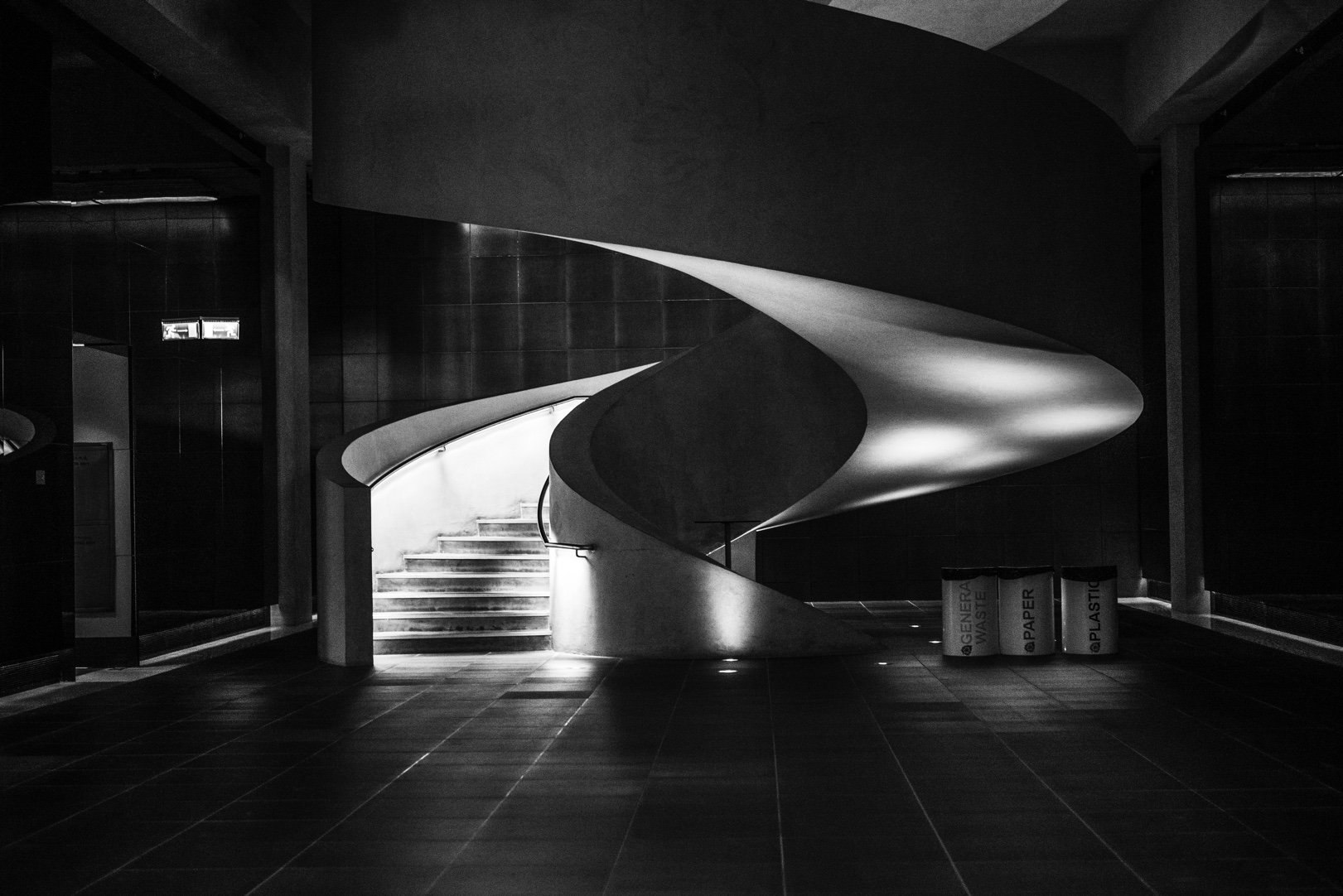 A curved staircase illuminated against a dark interior.