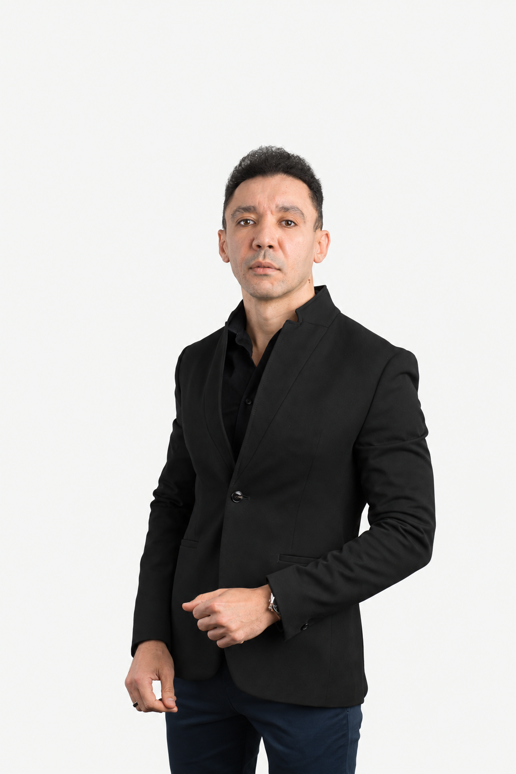 Tamer Tageldin in a black jacket, with one hand resting at his waist.