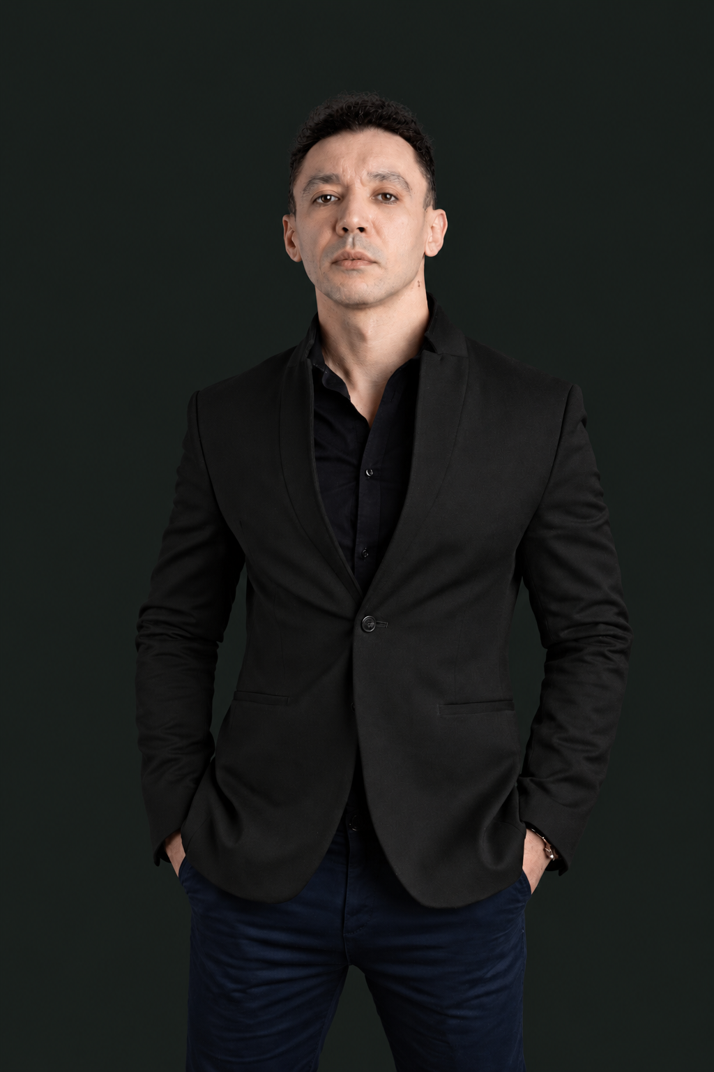 Front-facing portrait of Tamer Tageldin with his hands in his pockets.